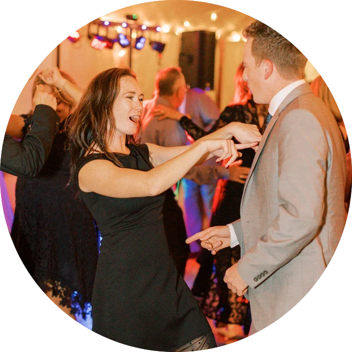 Two individuals gracefully dancing at a party, accompanied by the melodic tunes played by professional DJs from Maine.