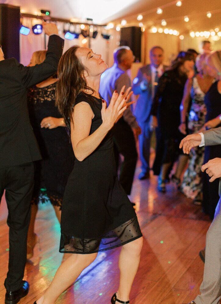 A lively ensemble of partygoers enjoying themselves on a vibrant dance floor at a maine wedding, complemented by the rhythmic beats curated by top-notch ME DJs.