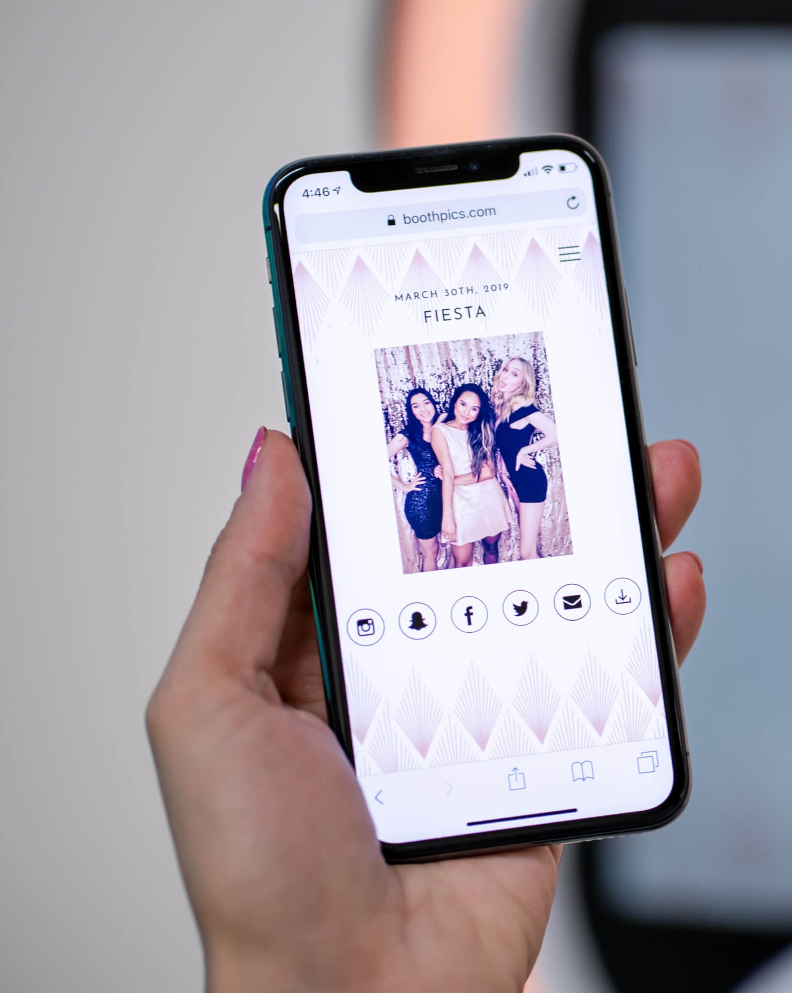 A person is holding up a phone with a photo of their wedding, showcasing the work of Maine wedding DJs.