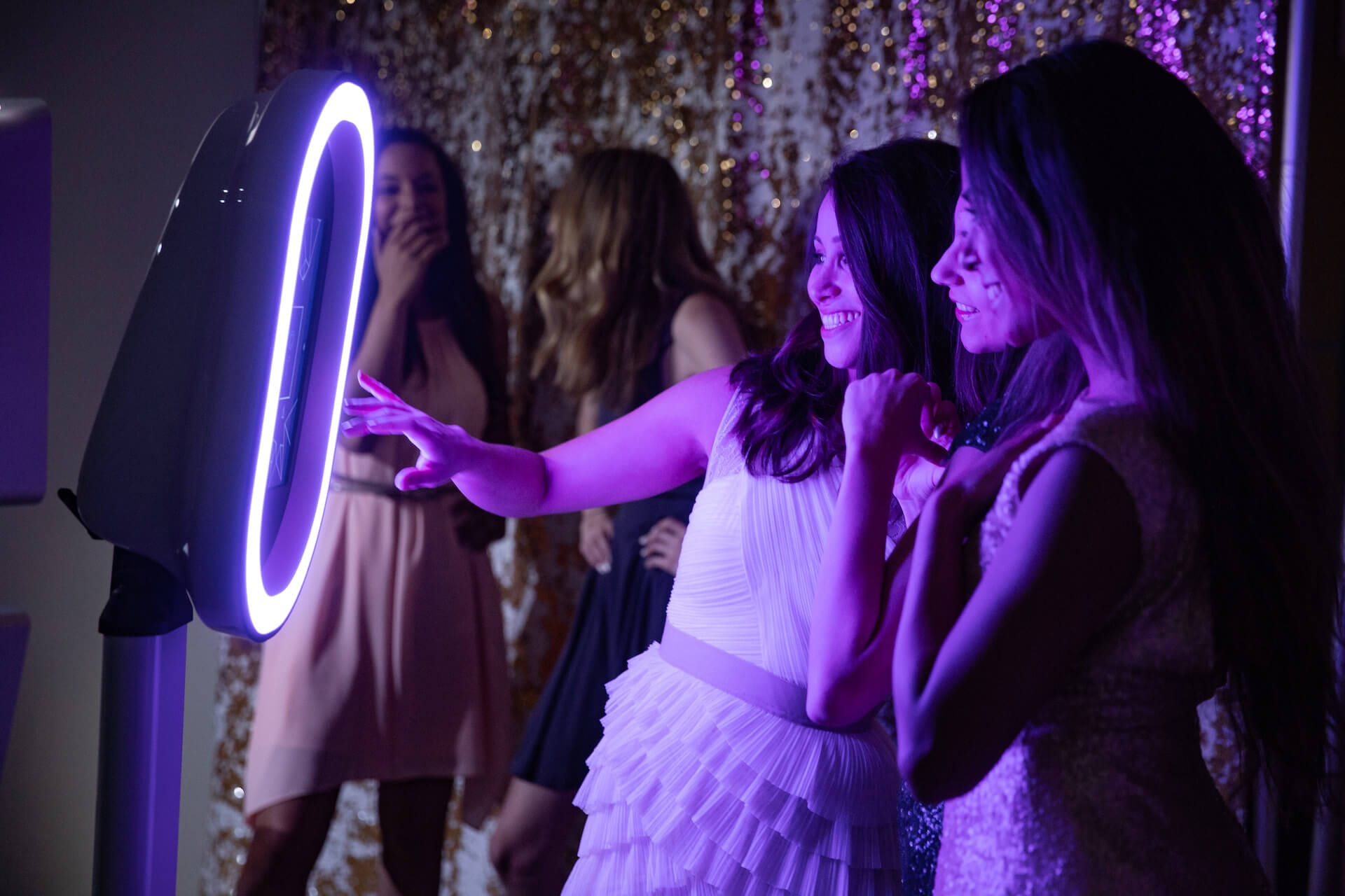 photo-booth-music-man Two women standing in front of a purple lighted photo booth at a Maine wedding.